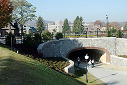 Photo of students walking under a bridge on campus. Link to Gifts of Real Estate
