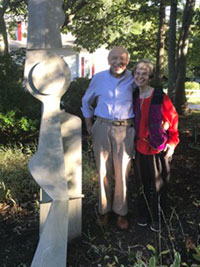 Dr. Milton Teichman and Dr. Sharon Leder stand by Dr. Teichman’s work in the sculpture garden at the Cape Cod Museum of Art in Dennis, Massachusetts