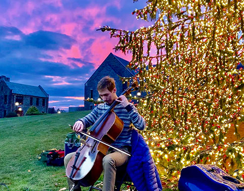 Alex Prizgintas ’22 playing the cello outdoors