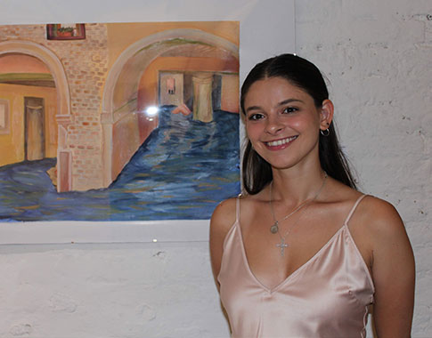 Alessia Amato ’20 poses by her oil painting Sunken Dream