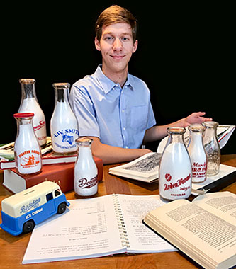 Alex Prizgintas ’22 with historical glass milk bottles